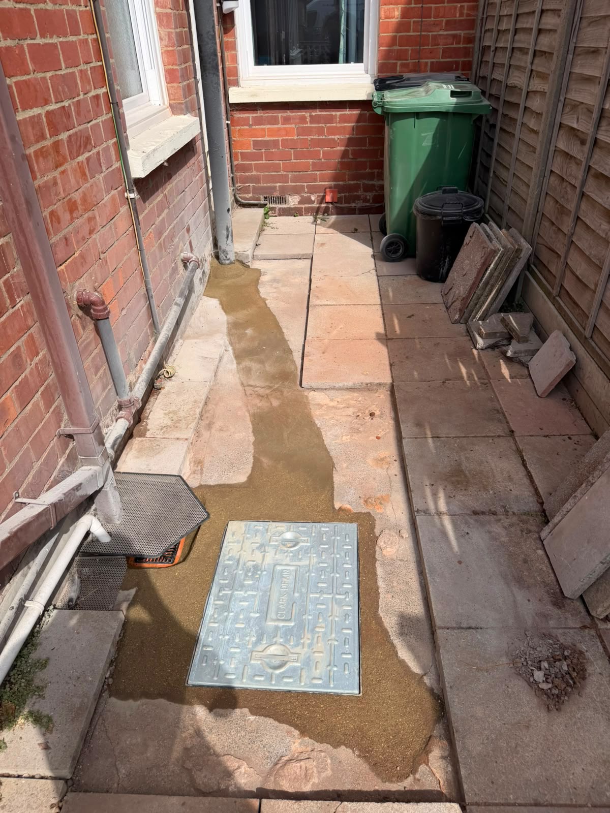 Reinstated rear yard with new sealed inspection chamber cover set into the paving